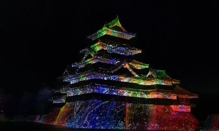 Matsumoto Castle lit at night with moat reflection